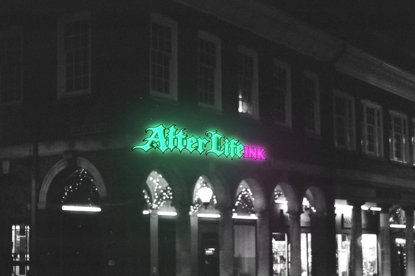 AfterLife Ink storefront at night with its neon sign